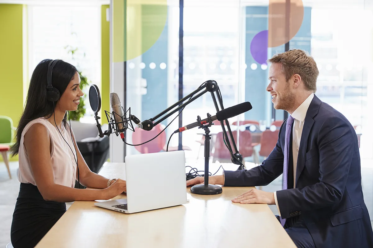 Young woman interviewing a guest in a studio for a podcast