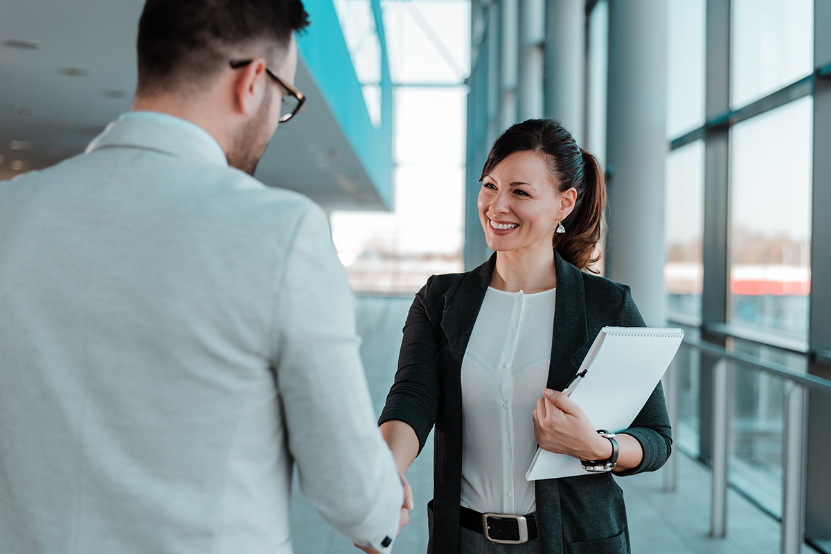 Business people handshake near the office building windows.