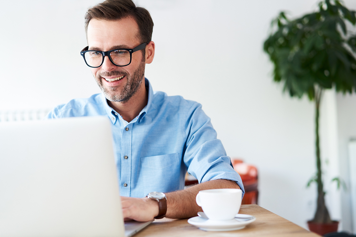 Handsome man at cafeteria, cafe working on laptop